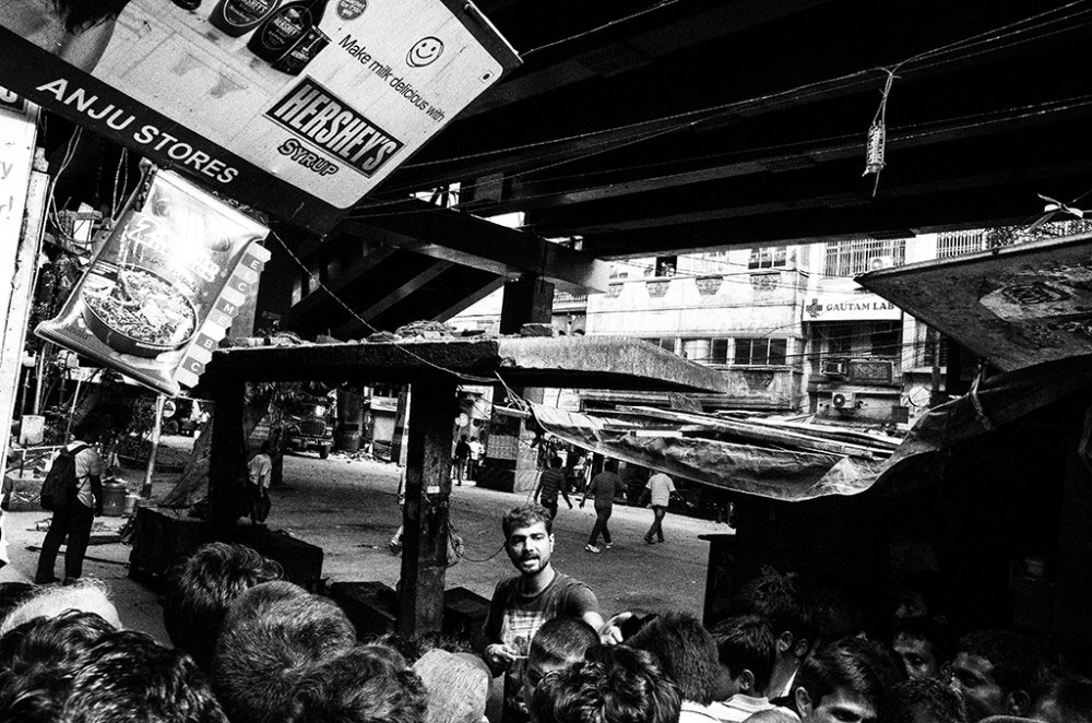 Girish Park,Kolkata,India-March 2016.A volunteer is seen diverting the people away from the crash site ,as the collapsed part of the flyover is seen in the background