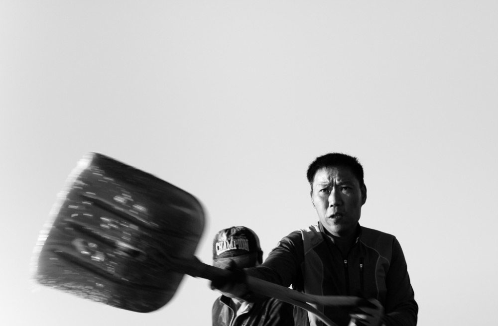 SINAN COUNTY, SOUTH KOREA - April 2015. Korean men shovel salt.