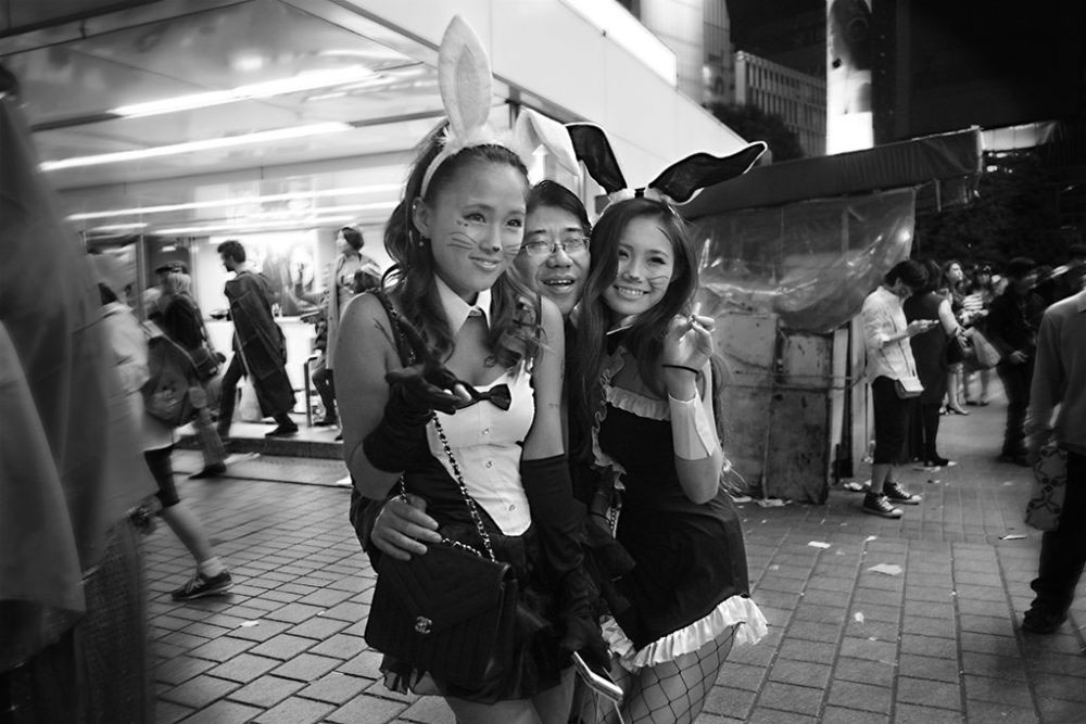 TOKYO, JAPAN - October 2015. 'Salaryman' poses with Playboy bunnies.