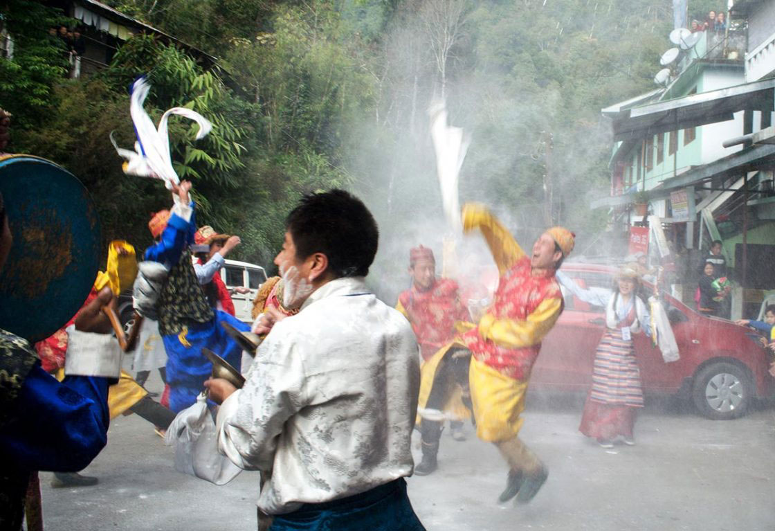 Sikkim, India- December 2015. Group of traditionally dressed "Bhutia" performer is celebrating "Lawsung" by throw paddy flour to each other in front of Rumtek Monastery. Lawsung is a five day's festival to offering thanks to God for good harvest, as well as this is the festival to welcome Tibetan upcoming year.